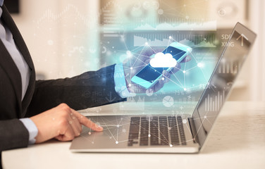 Business woman in homey environment using laptop with cloud technology concept