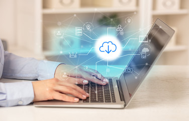 Business woman in homey environment using laptop with online storage and cloud technology concept