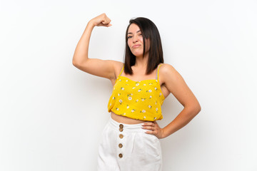 Young Mexican woman over isolated wall doing strong gesture