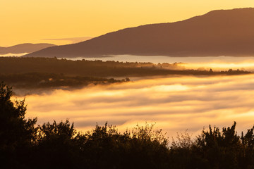 Fototapeta na wymiar Early morning sunrise of a fog enshrouded valley, Stowe, Vermont, USA