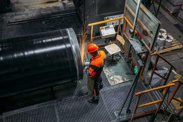 Male worker grinding butt weld pipe