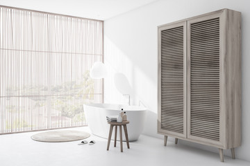 White bathroom corner with tub and wardrobe