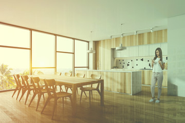 Young girl in wooden kitchen corner with table