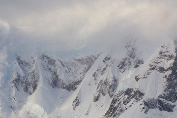 Antarctica. Paradise Harbor. Snowy mountains and clouds at sunrise.