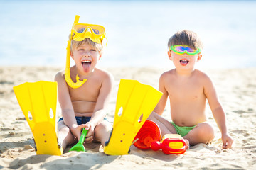 Pretty cute children on the beach having fun. Smiling kids in the summer time. Boys outdoors.