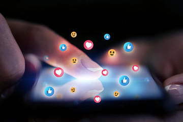 Finger touching phone with social media concept and dark background