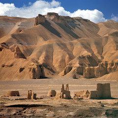 Afghanistan, Bamian Valley. Ancient earthen ruins blend seamlessly into the barren landscape of...