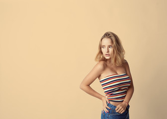 Obraz premium young cute and adorable girl on empty background, blond hair, empty for description, close up studio shot, passionate look