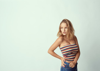 young cute and adorable girl on empty background, blond hair, empty for description, close up studio shot, passionate look