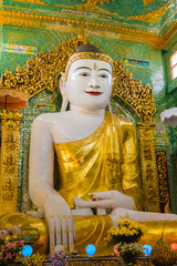 Myanmar. Mandalay. Sagaing Hill. Soon U Pon Nya Shin Paya. Giant Buddha surrounded by offerings.