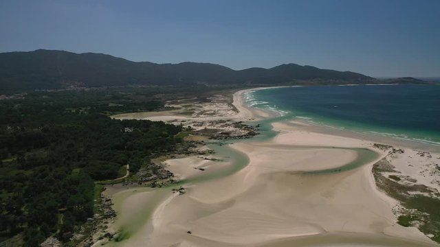 ocean waves, sandy beach with people walking along the shore, Carnota beach, Galicia, Spain