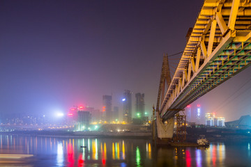 China, Chongqing, Construction of massive new Dongshuimen Bridge above Yangtze River on hazy autumn night