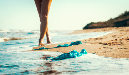 swimsuit in the sand on the beach near the sea surf on the background of a naked female figure and...