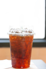 Ice americano coffee in PET plastice glass, fresh beverage with small ice refreshment in morning.
