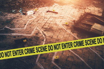 White chalk outline of killed body, blood an floor and yellow police caution tape with text - crime...
