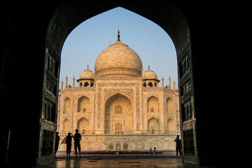 Fototapeta na wymiar Agra, Delhi, Taj Mahal. Large, open, carved doorway leads to the Taj Mahal, as people look at it