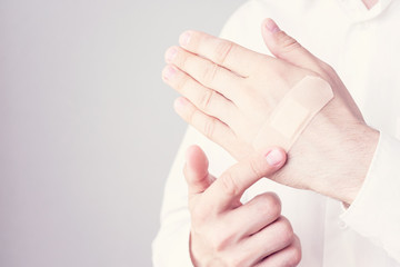 Men's hands, close up, stick plaster on hand, man with a wound on his finger medical plaster, toned