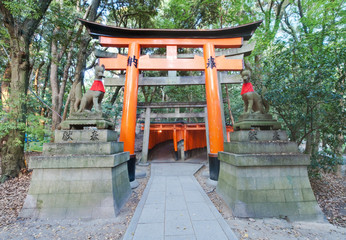 Torii flanked by Kitsune statues at Fushimi Inari Taisha, Kyoto, Japan