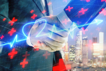 Double exposure of heart drawing on city view background with handshake. Concept of medical education