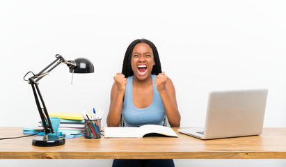 African American teenager student girl with long braided hair in her workplace frustrated by a bad situation
