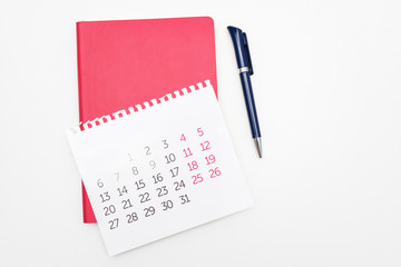 Calendar, pen and red notebook, white desktop, background, copy space, for recording, close up, top view