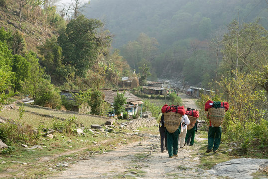 Nepal, Annapurna. Trekkers and porters on a path through the Middle Hills of Nepal.