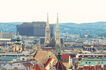 Panoramic view of the city at sunset with the spiers of the Votive Church or Votivkirche in Vienna in the distance.