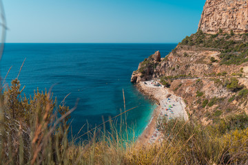 op view of people at colorful and picturesque Beach  lagoon  with turquoise  water in Javea , Alicante, Spain. Costa Blanca.