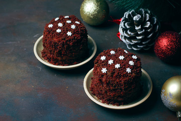 Festive dessert red brown velvet cake with white candy snowflakes on top on dark grungr background