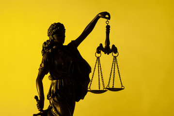 Figure of Justice holding scales over yellow