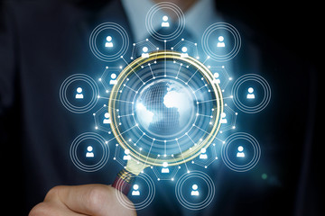 Businessman analyzes the business network with a magnifying glass.
