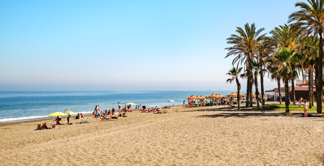 Fototapeta na wymiar people with colorful umbrellas at the beach, Malaga, Spain