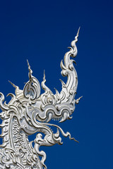 Rooftop architectural detail of dragon head on the new all white temple of Wat Rong Khun in Tambon Pa O Don Chai designed by Chalermchai Kositpipat.