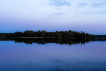 Blue hour after the sunset on the shores of the calm Saimaa lake in the Linnansaari National Park in Finland