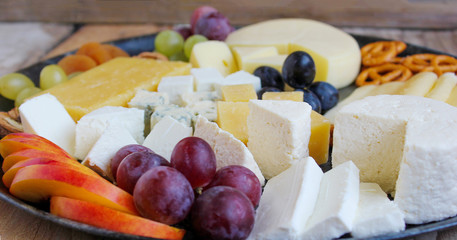 Rustic cheese platter with different cheese and grapes