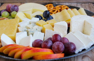 Rustic cheese platter with different cheese and grapes
