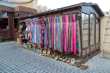 Azerbaijan, Baku. A storefront filled with colored scarves for sale.