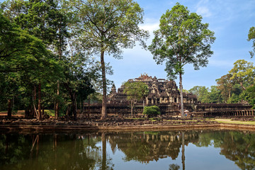 Fototapeta na wymiar Siem Reap, Cambodia. Ancient ruins and tower of the Baphuon Temple reflected in its moat at Angkor Thom