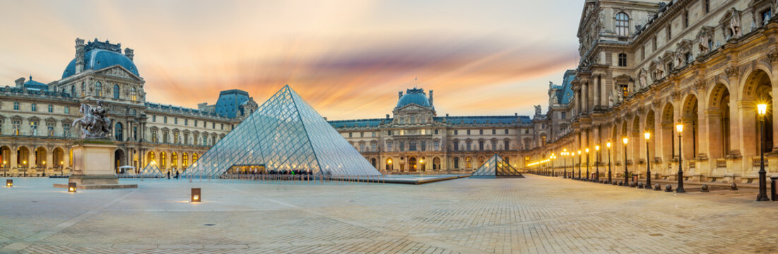 View of famous Louvre Museum with Louvre Pyramid at evening at sunset in Paris France