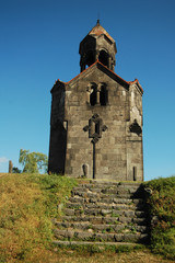 Fototapeta na wymiar Armenia, Haghpat, view of a catholic church built with stones and a tiled roof, with a stone staircase in the foreground