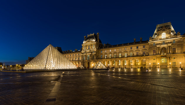 iew of famous Louvre Museum with Louvre Pyramid at evening