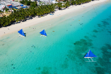 BORACAY, PHILIPPINES - 18 JUNE 2019: Aerial view of crowds of people and sailing boats on Boracay Island's White Beach