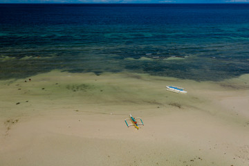 Fototapeta na wymiar Colorful wooden boats on a large beach at low tide (Anda, Bohol)