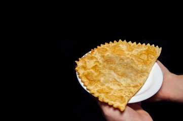 Caucasian dish cheburek on a white plate