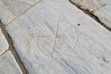 The Christian Wheel was a secret symbol of Christians, believed to precede the Ichthys fish, containing the hidden Greek letters IXOYE, found on a marble floor in the ancient city ruins of Ephesus, Tu