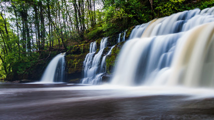 A scenic waterfall surrounded by forest in South Wales (Sgwd y Pannwr, Waterfall country, Wales)