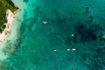 Aerial drone view of Banca boats over a coral reef on the Philippine island of Boracay