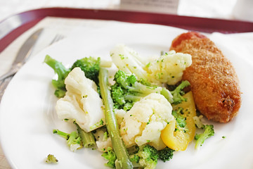 Lunch of the Kyiv cutlet, broccoli, cauliflower and asparagus on the white plate