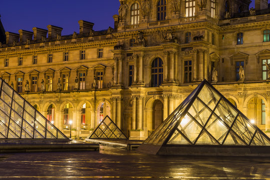 iew of famous Louvre Museum with Louvre Pyramid at evening