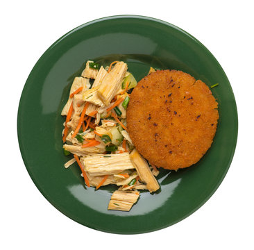 fishcake with soy asparagus and carrots, cucumbers and dilll. fish cutlet on a plate isolated. cutlet with vegetables top view
